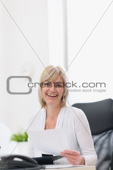 Happy mature business woman working at office