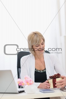 Happy senior business woman with present at work