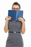 Student woman hiding behind notebook