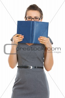 Student woman hiding behind notebook