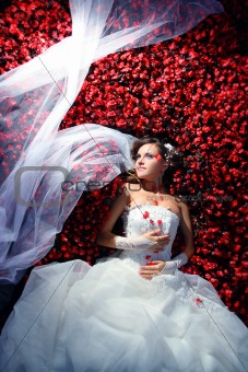 bride is lying in flowerbed 