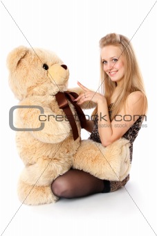 girl plays with stuffed bear