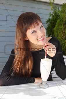 beautiful girl drinking a milkshake with a straw