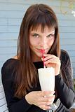 beautiful girl drinking a milkshake with a straw