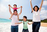 happy asian family jumping on the beach