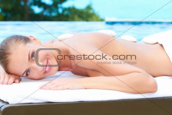 Beautiful woman lying on spa bed at outdoor