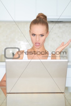Woman looking at laptop in horror