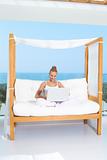 Woman on canopied seat with laptop