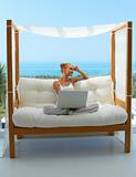 Woman with laptop on canopied seat