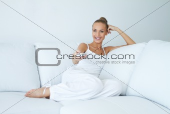 Happy woman watching tv on sofa