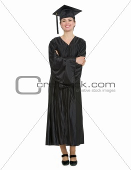 Full length portrait of woman in graduation cap and gown isolated
