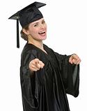 Smiling graduation student woman pointing on you isolated