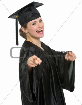 Smiling graduation student woman pointing on you isolated