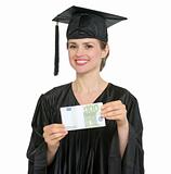Happy graduation student woman showing pack of euros isolated