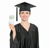 Smiling female graduation student showing pack of euros isolated