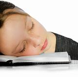 Closeup of girl sleeping  on an Open Book