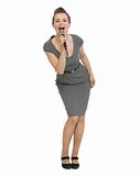 Full length portrait of happy woman singing in microphone isolated