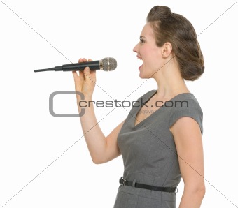 Woman singing in microphone isolated