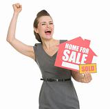 Excited landlord with home for sale sold sign isolated