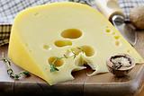 large piece of cheese varieties Maasdam on cutting board