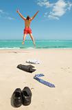 businessman jumping on the beach