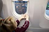 hands of child in the window of airplane
