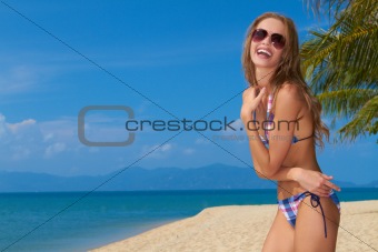 Smiling woman with sunglasses on sandy beach