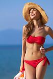 Smiling female in red bikini and straw hat