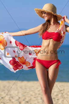 Beautiful blonde in a red bikini at the ocean