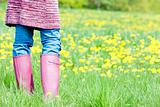 detail of woman wearing rubber boots on spring meadow