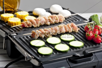 meat skewers and vegetables on electric grill