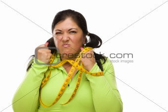 Attractive Frustrated Hispanic Woman Tied Up With Tape Measure Against a White Background.