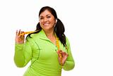 Attractive Middle Aged Hispanic Woman In Workout Clothes Showing off Her Tape Measure Against a White Background.