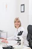 Smiling middle age doctor woman working at laboratory