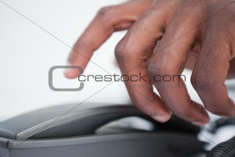 Close up of a masculine hand taking a phone handset