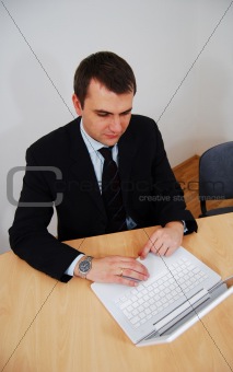man woirking on white laptop