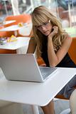 Attractive blonde woman working with a laptop in a cafe