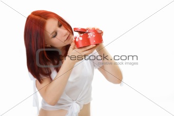 The girl with interest spies in a box with a gift, isolated over