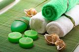 Spa concept of green color: the towel, soap and candles over sis