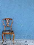 wooden chair alone with blue background

