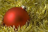 Red ornamental ball on yellow tinsel