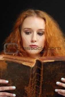 Young woman reading an old bible