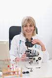 Middle age female researcher working with microscope