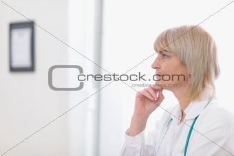 Portrait of middle age doctor woman looking on copy space