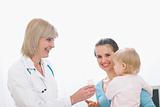 Middle age pediatric doctor giving pills bottle to mother with baby