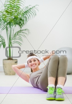 Happy fitness woman doing abdominal crunch