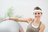 Smiling woman holding fitness ball