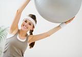 Smiling slim woman making exercises with fitness ball