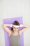 Smiling healthy woman laying on fitness mat