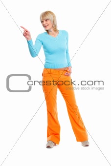 Full length portrait of elderly woman pointing in corner